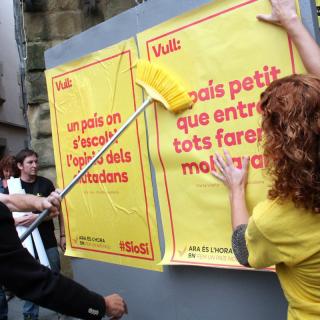 Enganxada del primer cartell de la campanya a Vic 