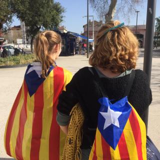 Una mare i la seva filla amb estelades a l'esquena camí de l'acte amb Puigdemont a Perpinyà