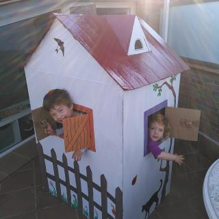 Amb un cartró gran de frigorífic trobat casualment al costat de casa hem construït una caseta pel Bernat i la Cèlia.