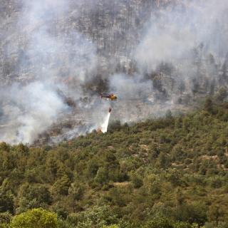 Un helicòpter llença aigua a l'incendi forestal de Baldomar