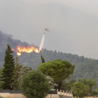 Un helicòpter llança aigua damunt les flames, a Artesa de Segre