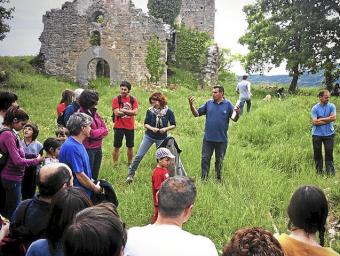 L’arqueòleg Francesc Busquets, al centre, durant la visita a les excavacions del castell; al fons, l’església del segle XI Xavier Bardolet