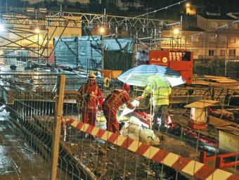 Operaris treballant aquest dimecres a la nit, sota la pluja, preparant el dispositiu per desplaçar els mòduls de la nova plataforma del pont de Sant Q Jordi Puig