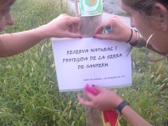 Dues veïnes de la Serradesentferm col·locant un rètol durant l’acció simbòlica d’oposició a la pota sud que van fer diumenge