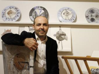 Paco Cámara en una de les seves cadires artístiques i davant d’uns plats i unes peces blanques amb papers pintats Griselda Escrigas