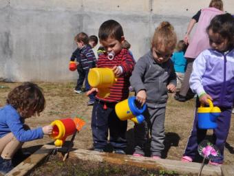 Els nens de l'Escola Bressol Municipal La Ginesta reguen l'hort Enrique Canovaca
