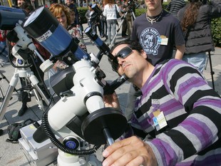 Un home observa el sol a través d'un telescopi. /  M.MARTINEZ