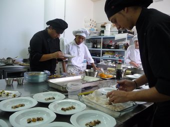 Els alumnes del cicle de cuina mentre elaboren els plats.  ROSER ROYO