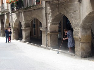 Una àvia de Juneda escombra davant de casa seva, al carrer Major de Juneda.
