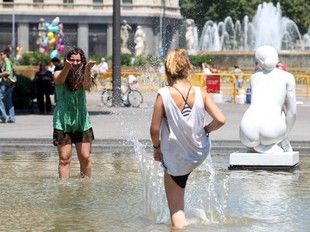 Dues noies es refresquen ahir en una font de Barcelona. ORIOL DURAN