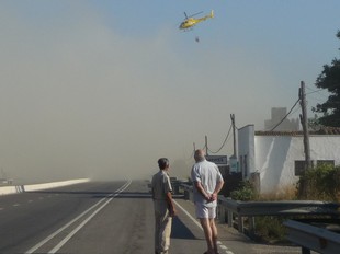 Dos veïns miren encuriosits les maniobres de l'helicòpter al mig del fum  R.R