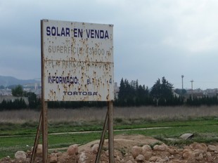 Els terrenys de la piscina i de la zona esportiva, amb el cartell del solar en venda. G.M