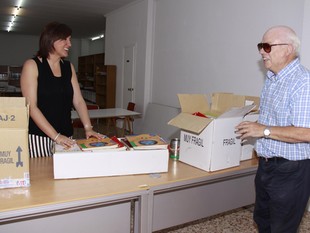Mª Josep Català fa entrega d'una capsa de material al Banc de Llibres. /  CEDIDA