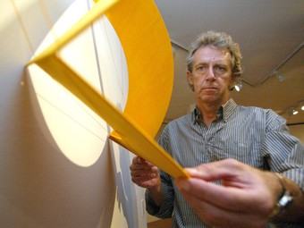 Tom Carra, mostrant una de les seves obres. A baix, l'obra Reverberatio, feta amb fusta i llum, i la titulada
			Ad infinitum.
		  JUDIT FERNÀNDEZ