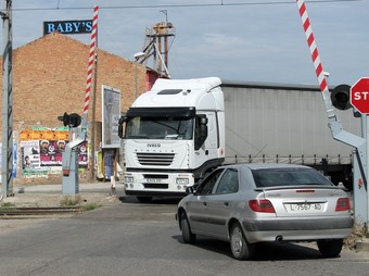 Un camió i un cotxe creuant al mateix temps pel pas a nivell principal de Mollerussa.