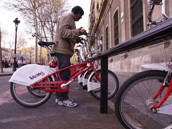 Un usuari agafa una bicicleta en una estació de Barcelona.  LUIS ALBERTO VILLALBA