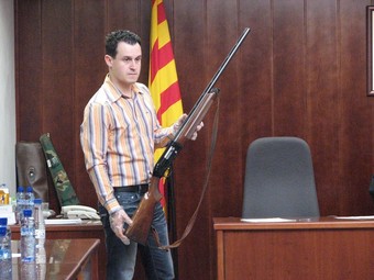 Un dels encarregats de la sala mostra al jurat l'arma homicida.