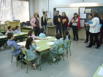 La consellera Carme Capdevila ensenya els llibres als alumnes de l'escola Santa Anna, a Premià de Dalt, ahir al matí. /  GERARD ARIÑO