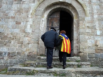Dos visitants aprofitaven la consulta per visitar Sant Jaume de Frontanyà.  ORIOL DURAN