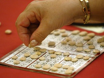 Una jugadora marca els números del seu cartró amb guixes, llegums. GABRIEL MASSANA