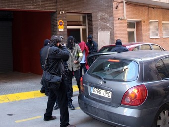 Els Mossos s'emporten un dels detinguts en un domicili de Castelldefels, ahir.  ACN