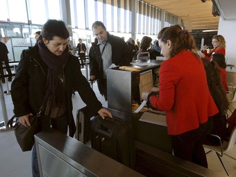 Una dona factura la maleta abans d'embarcar al primer vol comercial cap a París. EFE