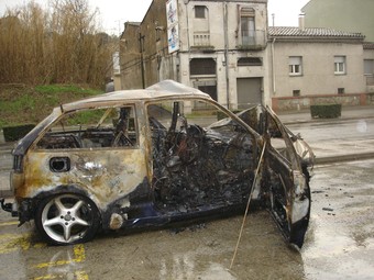 El cotxe cremat, davant les cases dels rescatadors del conductor que va quedar atrapat.  TURA SOLER
