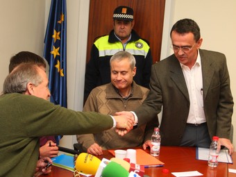 El nou alcalde d'Amer, Narcís Junquera, es dona la ma amb el fins ahir alcalde, Xavier Targa. LLUÍS SERRAT
