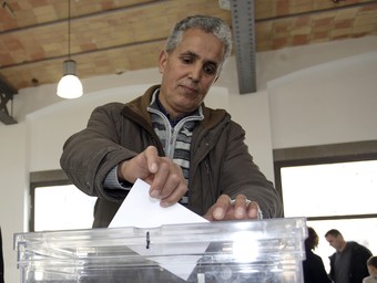 Un veí de Palafrugell diposita el seu vot a l'urna. JULIETA SOLER