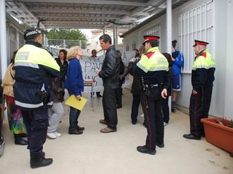 Un grup de pares i mares i efectius dels mossos i de la policia local, ahir a l'institut.  M.L