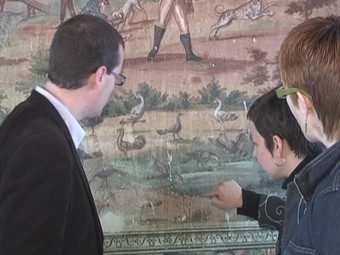 L'alcalde de la localitat observa les deficiències del tapissos a restaurar. /  CEDIDA