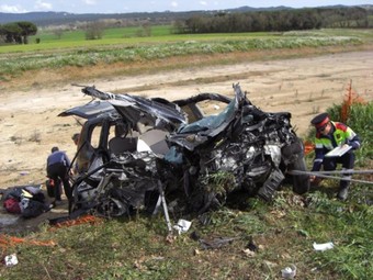 Un mossos inspecciona el cotxe, al lloc de l'accident .  JOAN RAMON REINA/ ACN