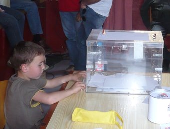 Un noi vigila l'urna, poc abans de fer el recompte dels vots. A.V