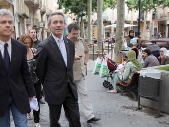 El líder de Plataforma per Catalunya, Josep Anglada, passant per davant d'un grup de dones amb mocador al cap, al Vendrell. J. FERNÀNDEZ