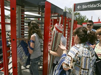 Els viatgers que arribaven ahir al matí a l'estació de Castelldefels Platja TENIEN PROBLEMES PER PASSAR PELS TORNS AMB LES BOSSES, NEVERES I UMBEL·LES ROBERT RAMOS