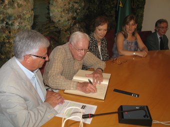 Jimmy Carter signant dimecres al llibre d'honor.  EL PUNT