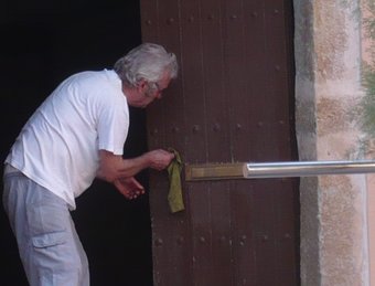 El rector de Gualta neteja la porta de la rectoria. Albert Vilar