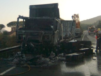 El camió totalment cremat a la carretera, ahir. JOSEP JOAN MIQUEL