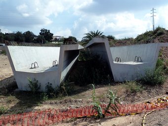 Bigues de l'estructura apilades en un camp al costat de les obres J.A
