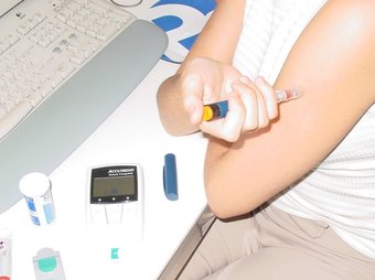 Una noia diabètica, s'injecta insulina. L. B
