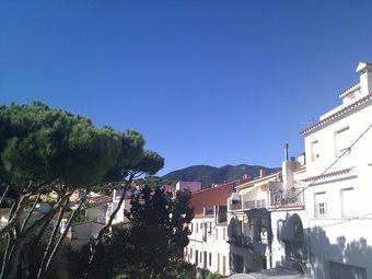 Un dels carrers del poble de Sant Iscle amb la silueta del Montnegre al fons. E.F