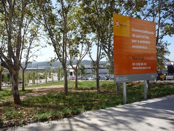 Un cartell anuncia la comercialització del nou parc industrial de nova generació a El Martinet. C.A.F