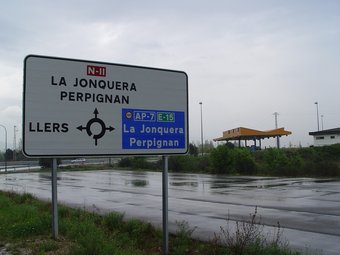Un cartell en què es pot apreciar la limitació de moviments per entrar a l'autopista des de Figueres, amb el peatge al fons. ROBERT CARMONA