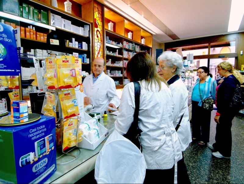 Un grup de gent espera en una oficina de farmàcia per comprar