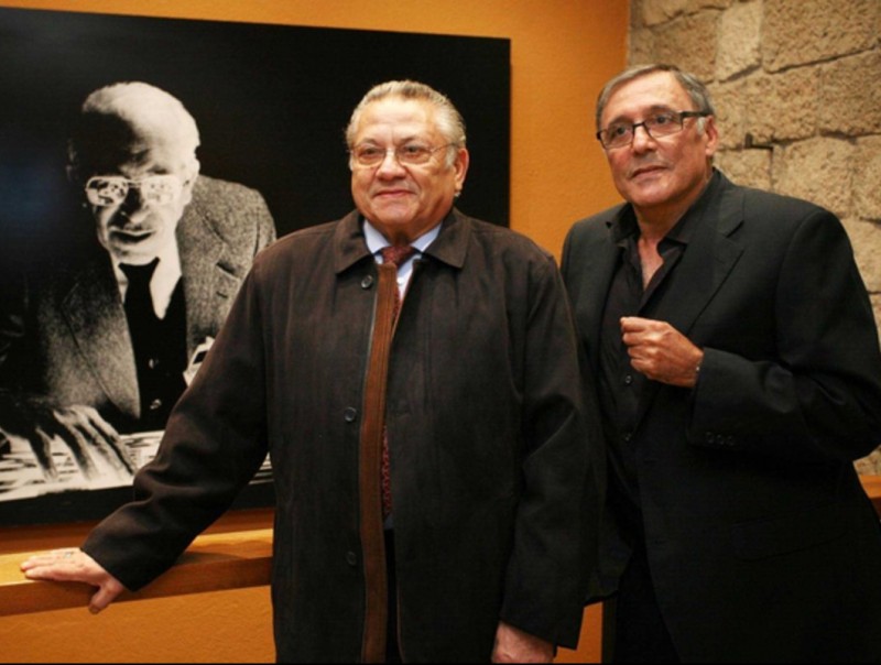 Els fills d'Agustí Centelles, Sergi (esquerra) i Octavi (dreta), al costat d'una fotografia del seu pare de l'any 1977. ARXIU