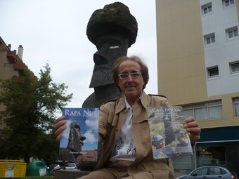 Francesc Amorós, retratat amb el llibre que presenta i un d'anterior també sobre Pasqua davant del moai de l'agermanament d'Olot amb l'illa. J.C