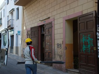 Un operari carrega material per a les obres d'accessibilitat del local de la plaça de la Font. M.L