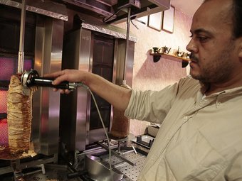 Khalid Haddach tallant la carn per preparar un kebab, al cafè Tanger de Girona. LLUÍS SERRAT