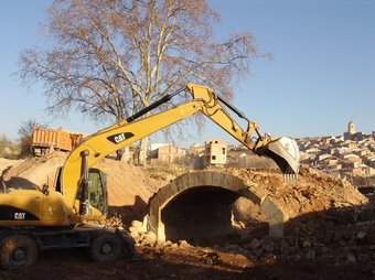 Una màquina enderrocant l'antic pont del Pinell de Brai, a causa de les obres de millora de la carretera. CEDIDA