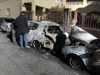 Els cotxes afectats per l'incendi, i agents de la investigació dels Mossos. LL. SERRAT